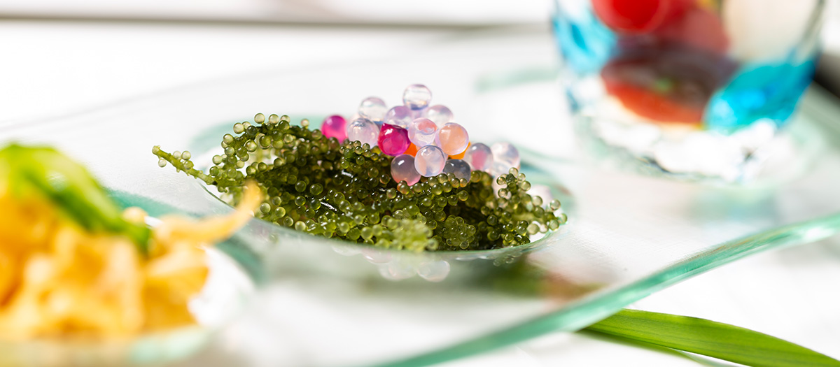 日替わりの前菜は爽やかな琉球ガラスに盛られて。こちらは海の宝石“海ブドウ”